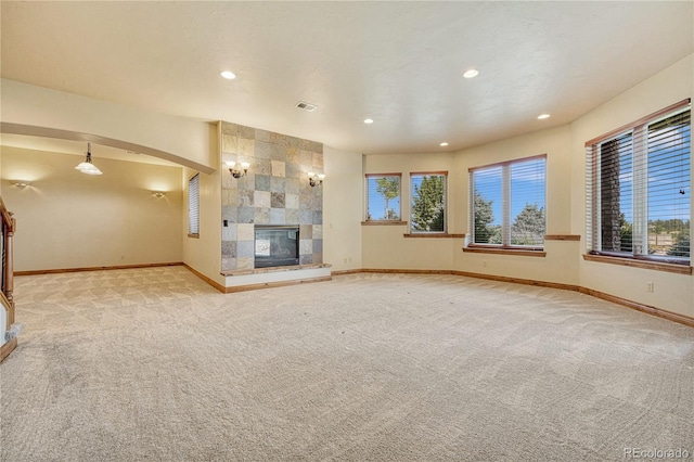 unfurnished living room with light carpet and a fireplace