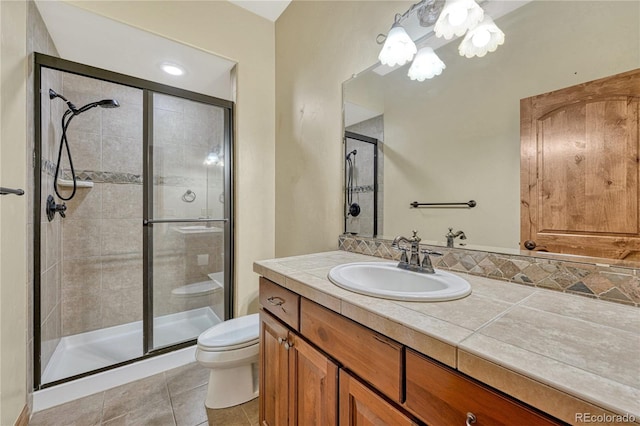 bathroom with walk in shower, tile patterned flooring, vanity, and toilet