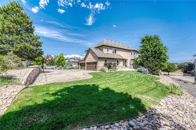 rear view of house featuring a lawn and a garage