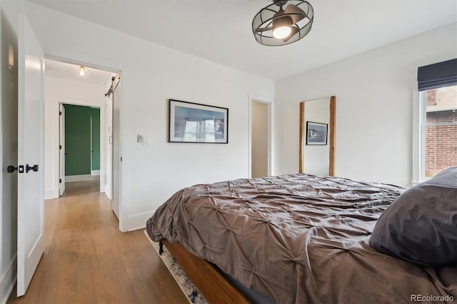 bedroom with baseboards and light wood finished floors