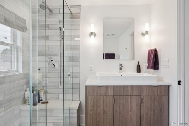 full bathroom featuring vanity, a shower stall, and visible vents