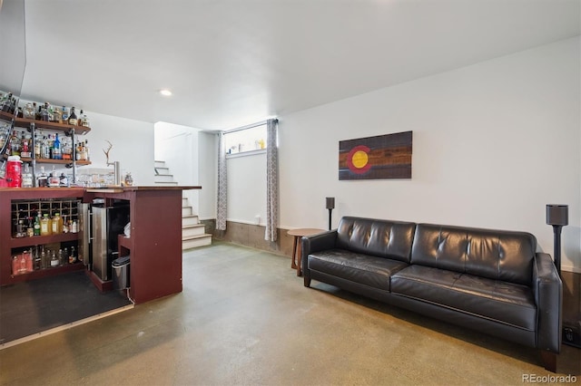 living area featuring recessed lighting, concrete floors, a bar, and stairway