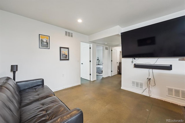living area with baseboards, concrete floors, and visible vents