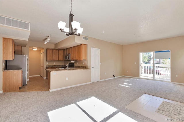 kitchen with stainless steel appliances, open floor plan, a sink, and light colored carpet