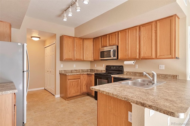 kitchen with stainless steel microwave, freestanding refrigerator, electric range, a sink, and light countertops