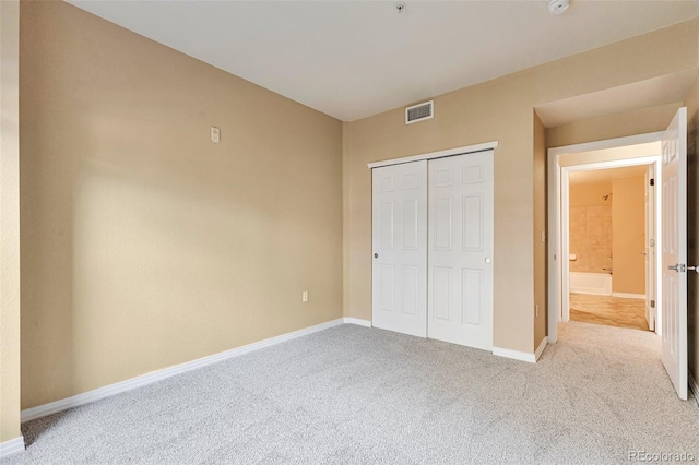unfurnished bedroom with carpet, baseboards, and a closet