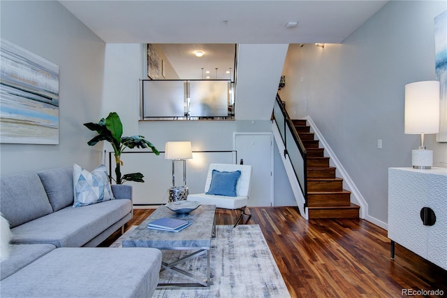 living room with stairs, baseboards, and wood finished floors