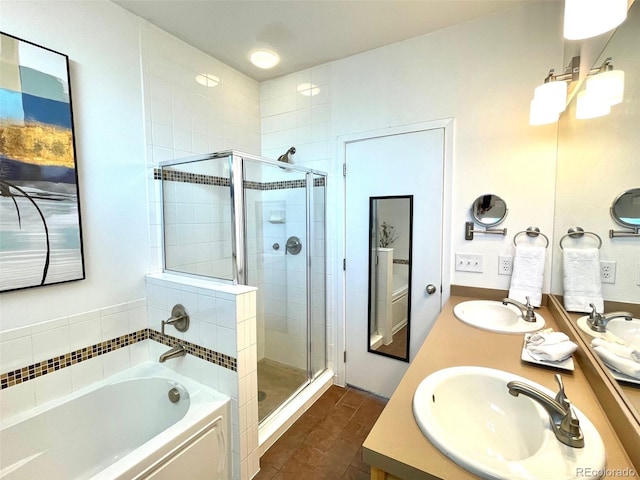 bathroom with double vanity, a stall shower, a garden tub, and a sink