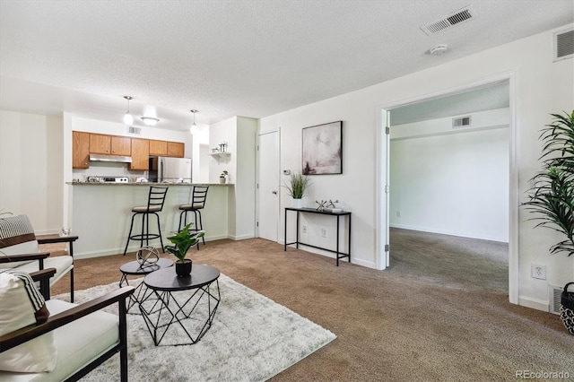 carpeted living room featuring a textured ceiling