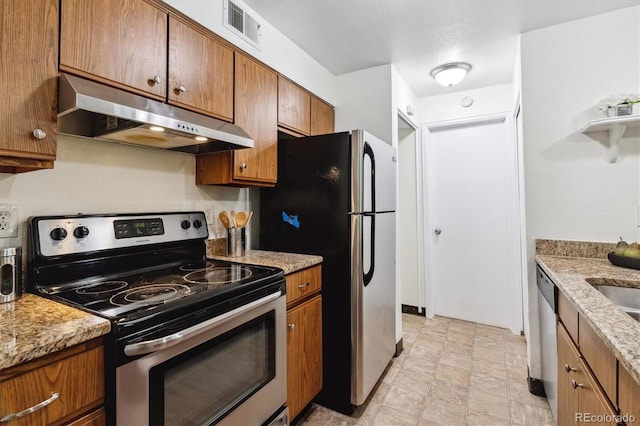 kitchen with appliances with stainless steel finishes and light stone countertops