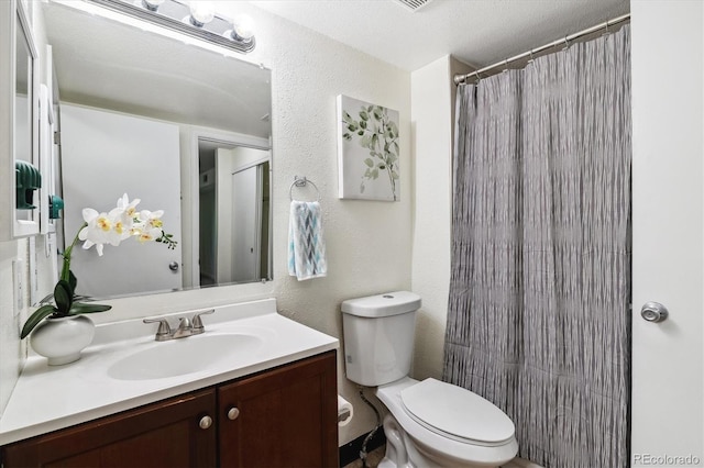 bathroom featuring toilet, vanity, and a textured ceiling