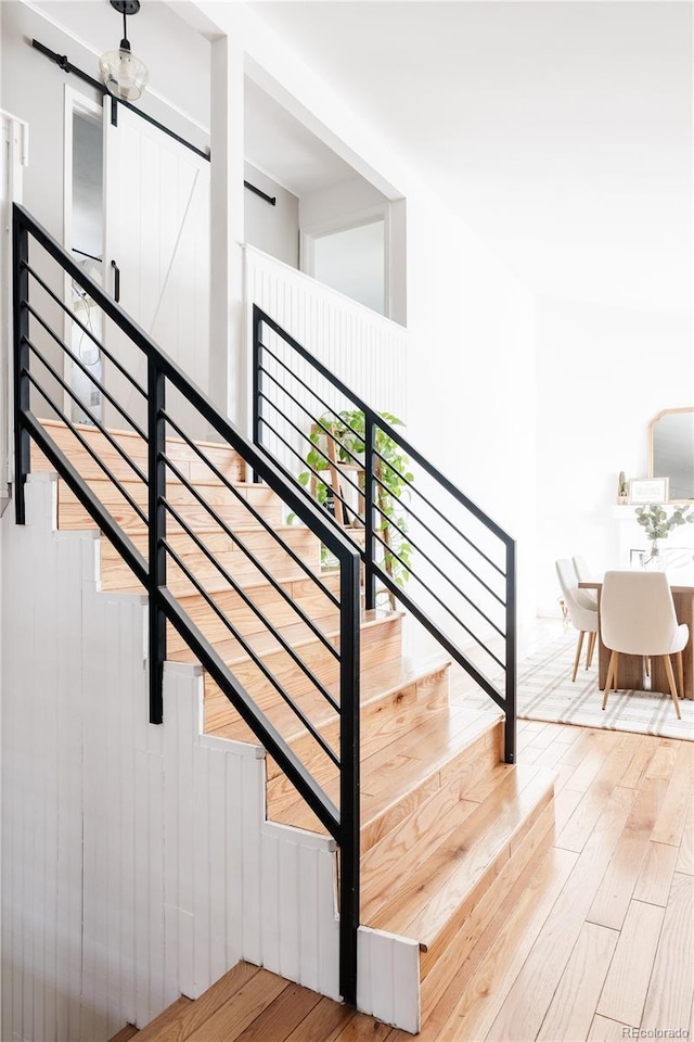 stairway featuring hardwood / wood-style flooring and a barn door