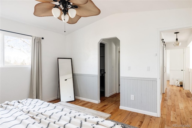 unfurnished bedroom with lofted ceiling, ceiling fan, and light wood-type flooring