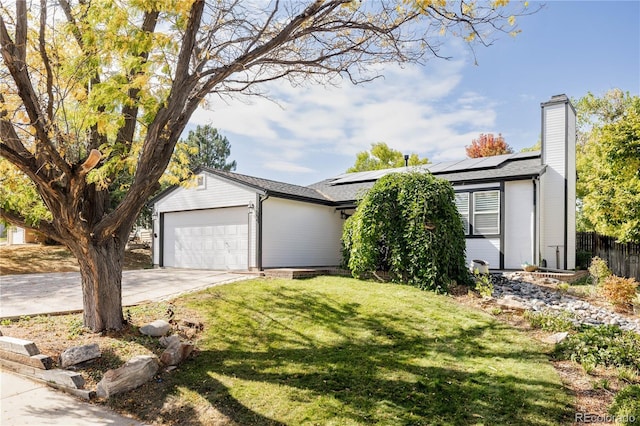 ranch-style home featuring a garage, a front yard, and solar panels