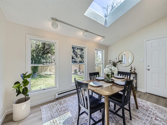9540 King Way, Westminster, CO 80031 - dining room featuring a skylight, track lighting, a baseboard radiator, and plenty of natural light