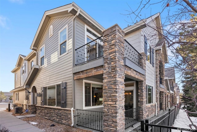 view of side of property featuring central AC unit and a balcony