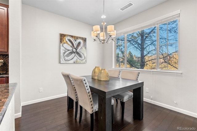 dining area featuring dark hardwood / wood-style flooring and a notable chandelier