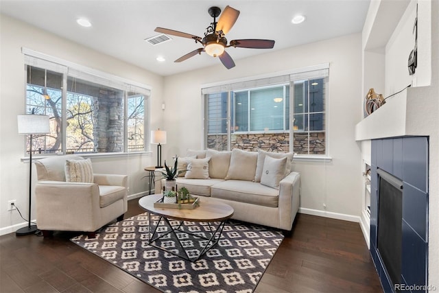 living room with dark hardwood / wood-style flooring and ceiling fan