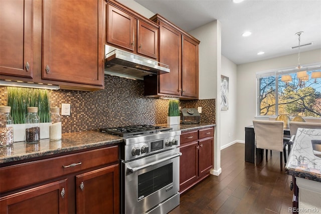 kitchen featuring dark wood-type flooring, hanging light fixtures, high end stainless steel range oven, dark stone counters, and decorative backsplash