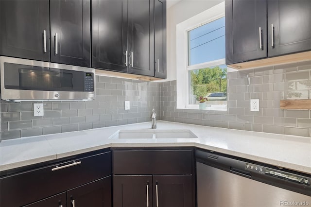 kitchen featuring stainless steel appliances, sink, and backsplash