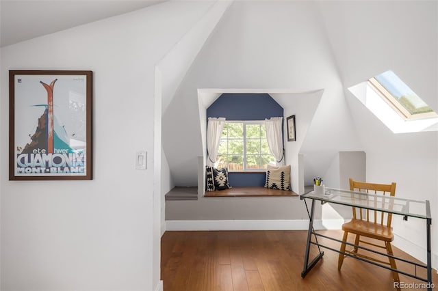 interior space with hardwood / wood-style floors and vaulted ceiling with skylight