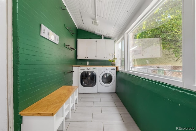 laundry room featuring separate washer and dryer, light tile patterned floors, and cabinets