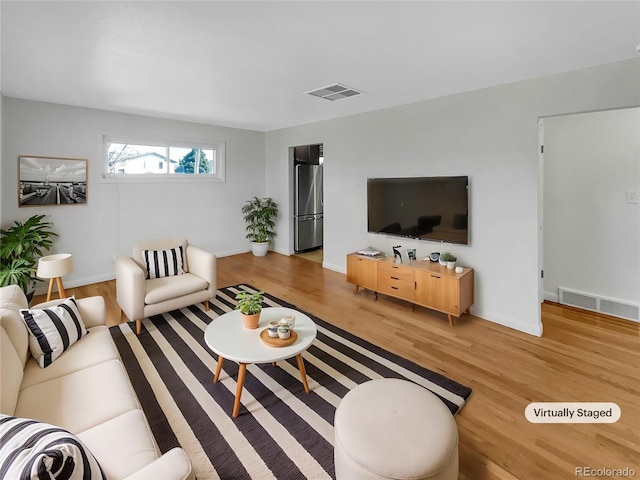 7180 Zuni St, Denver, CO 80221 - living area featuring baseboards, visible vents, and light wood finished floors