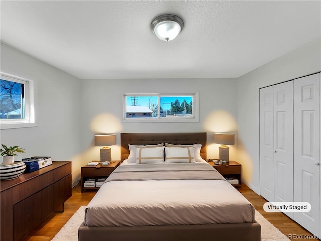 7180 Zuni St, Denver, CO 80221 - bedroom with multiple windows, a closet, and light wood-type flooring