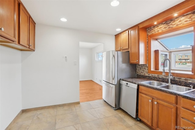 7180 Zuni St, Denver, CO 80221 - kitchen featuring dishwasher, dark countertops, brown cabinets, and a sink