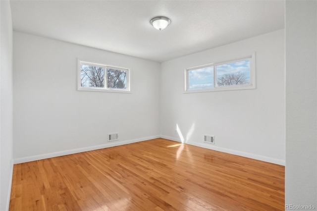 7180 Zuni St, Denver, CO 80221 - spare room with visible vents, a healthy amount of sunlight, baseboards, and light wood-style floors
