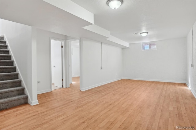 7180 Zuni St, Denver, CO 80221 - below grade area with stairway, baseboards, and light wood-style floors