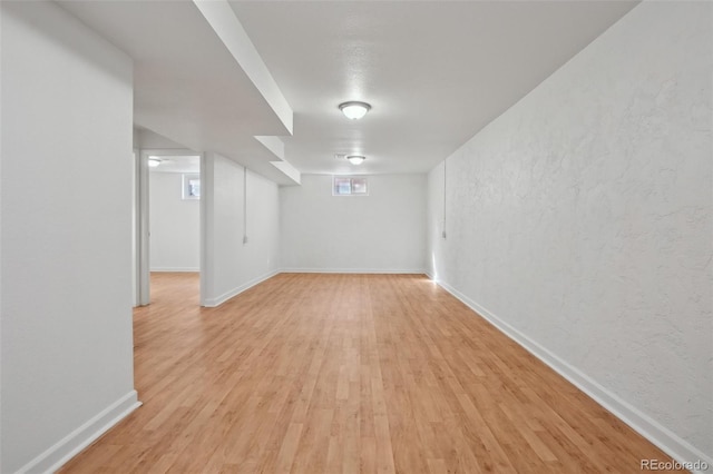 7180 Zuni St, Denver, CO 80221 - below grade area featuring a textured wall, baseboards, and light wood finished floors