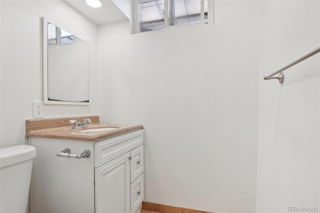7180 Zuni St, Denver, CO 80221 - bathroom featuring toilet, vanity, and a textured wall