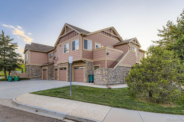 5757 S Algonquian Way Unit E, Aurora, CO 80016 - view of front of home with board and batten siding, driveway, an attached garage, and stone siding