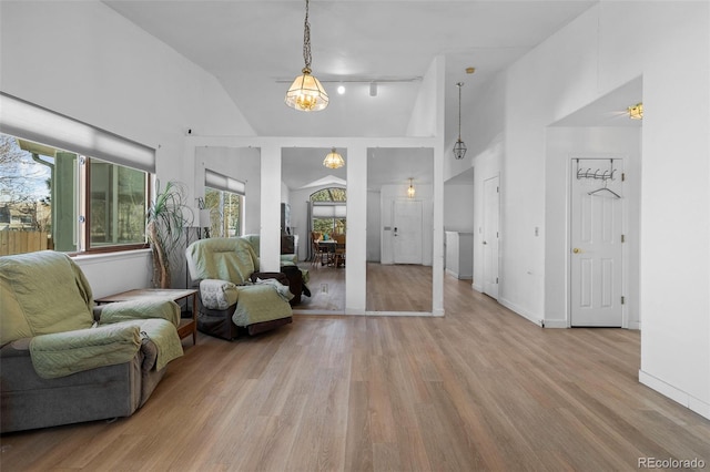 sitting room featuring baseboards, high vaulted ceiling, and wood finished floors