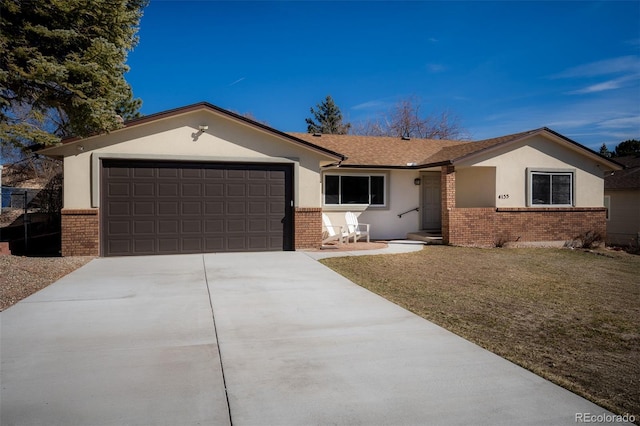 ranch-style house with an attached garage, brick siding, concrete driveway, stucco siding, and a front lawn