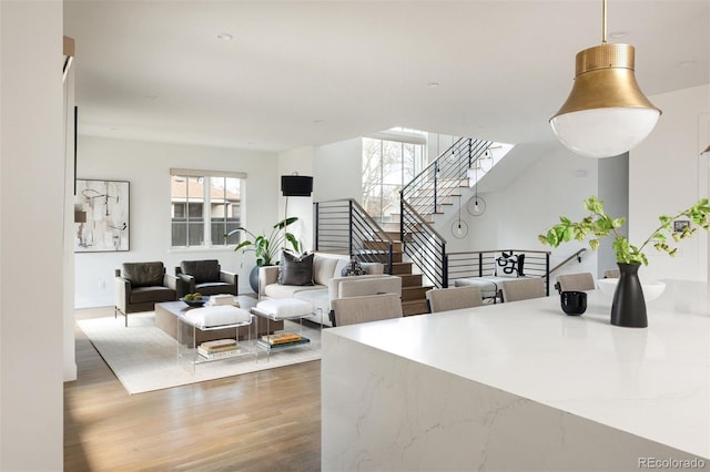 living room with stairs and wood finished floors