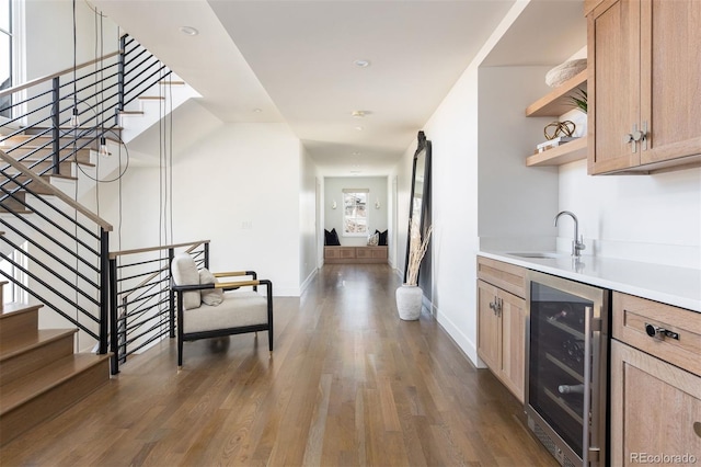 bar with a sink, wine cooler, stairway, and wood finished floors