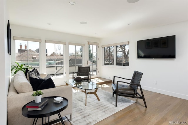 living room featuring baseboards, wood finished floors, and recessed lighting