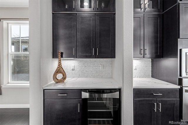 kitchen with hardwood / wood-style floors, wine cooler, light stone counters, and decorative backsplash