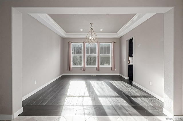 unfurnished dining area featuring ornamental molding, a raised ceiling, and a notable chandelier