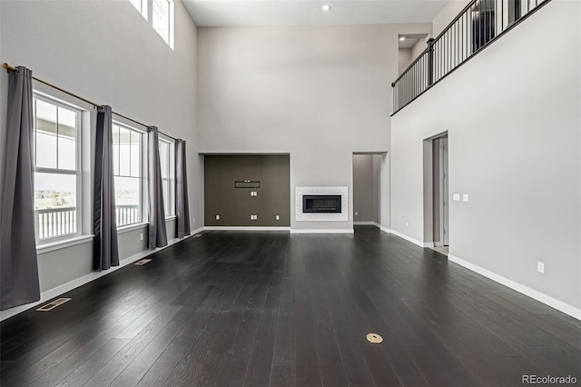 unfurnished living room featuring hardwood / wood-style floors and a high ceiling