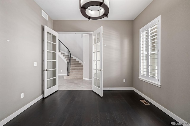 unfurnished dining area with dark hardwood / wood-style floors and french doors