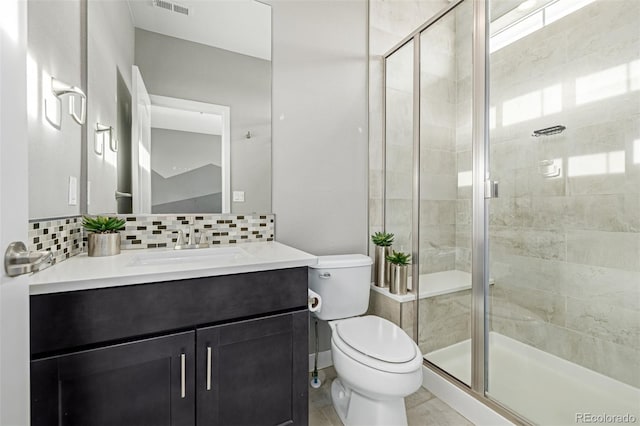 bathroom with vanity, toilet, an enclosed shower, and decorative backsplash