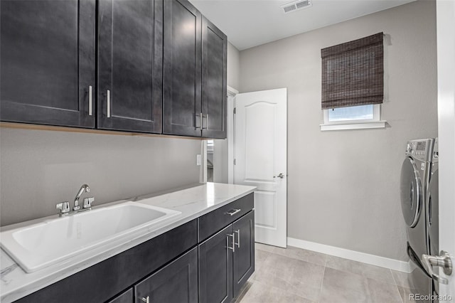 laundry area featuring cabinets, washer and dryer, sink, and light tile patterned floors