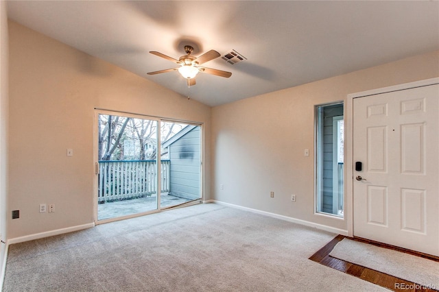 carpeted foyer entrance featuring visible vents, baseboards, a ceiling fan, and vaulted ceiling