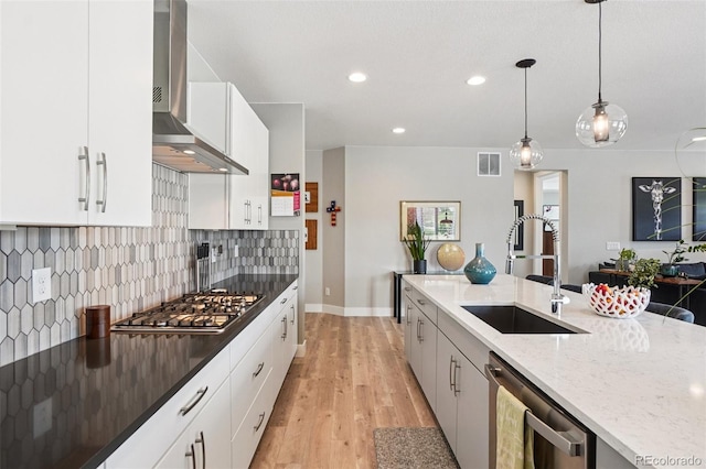 5680 Saddle Skirt St, Parker, CO 80134 - kitchen with wall chimney range hood, stainless steel appliances, dark stone countertops, decorative backsplash, and light wood finished floors