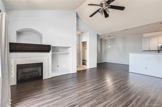 14251 E 1st Dr Unit 305, Aurora, CO 80011 - unfurnished living room featuring a ceiling fan, wood finished floors, a brick fireplace, high vaulted ceiling, and built in features