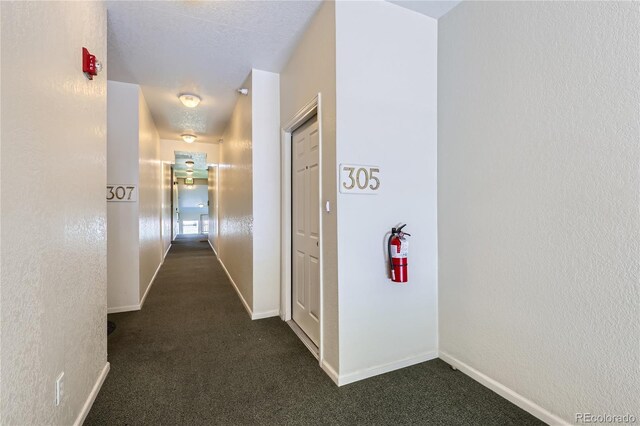 14251 E 1st Dr Unit 305, Aurora, CO 80011 - hall with dark colored carpet and a textured wall