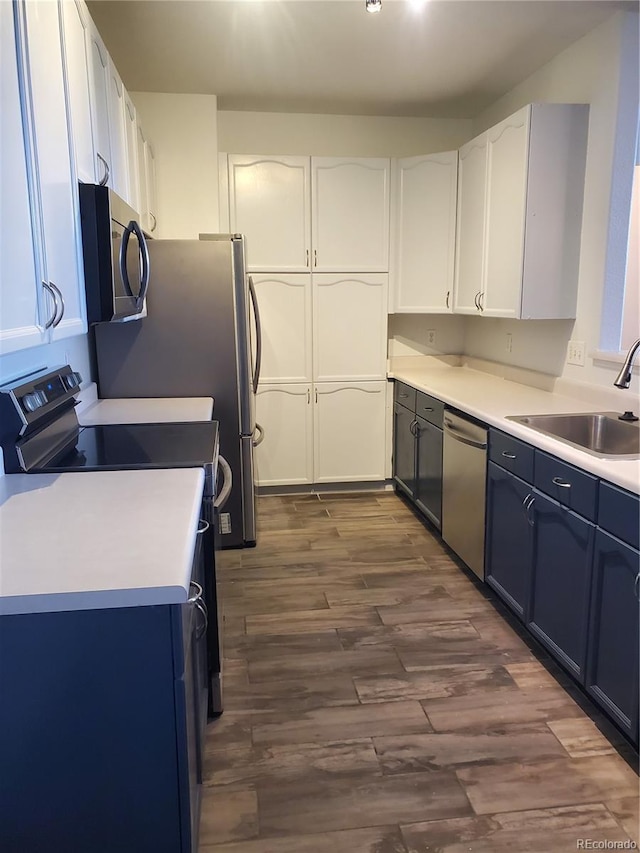 14251 E 1st Dr Unit 305, Aurora, CO 80011 - kitchen featuring appliances with stainless steel finishes, dark wood finished floors, white cabinets, and light countertops